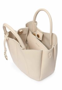 Beige neplederen shoppersac met gestructureerde zijkanten, dubbele handvatten en een binnenvak met rits, voorzien van gouden hardware en een knoopsluiting.