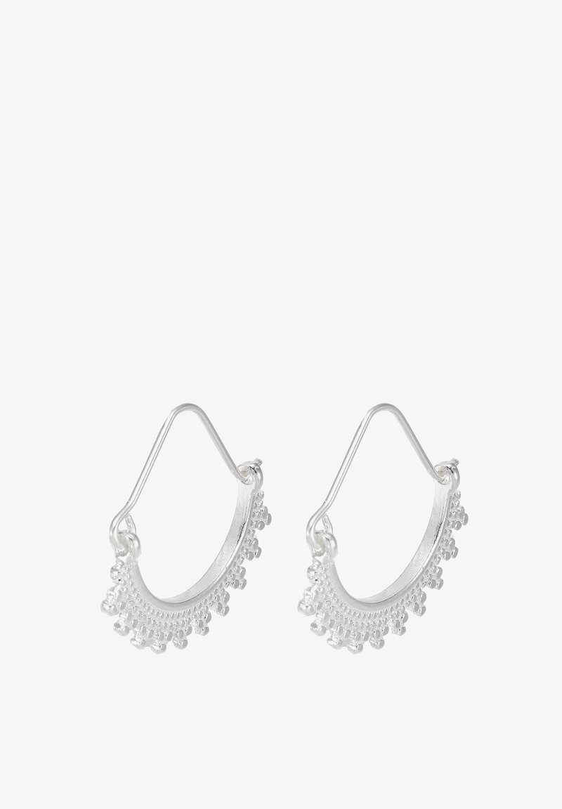 Boucles d'oreilles créoles en argent avec un motif détaillé de petites perles rondes le long du bord inférieur, présentées sur un fond blanc.