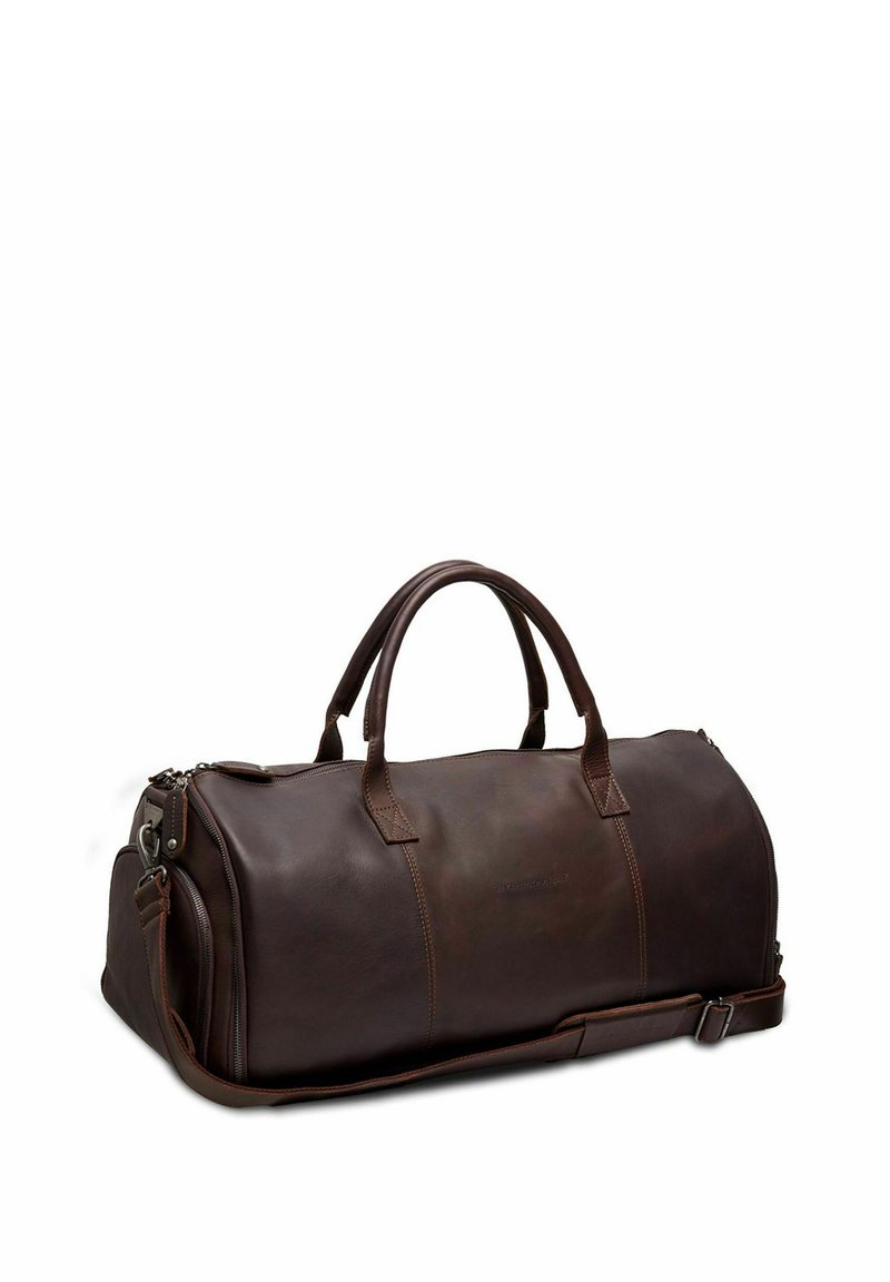 Bolsa de viaje de cuero marrón con asas dobles, correa de hombro ajustable, cierre con cremallera y un sutil detalle de costura para mayor durabilidad.