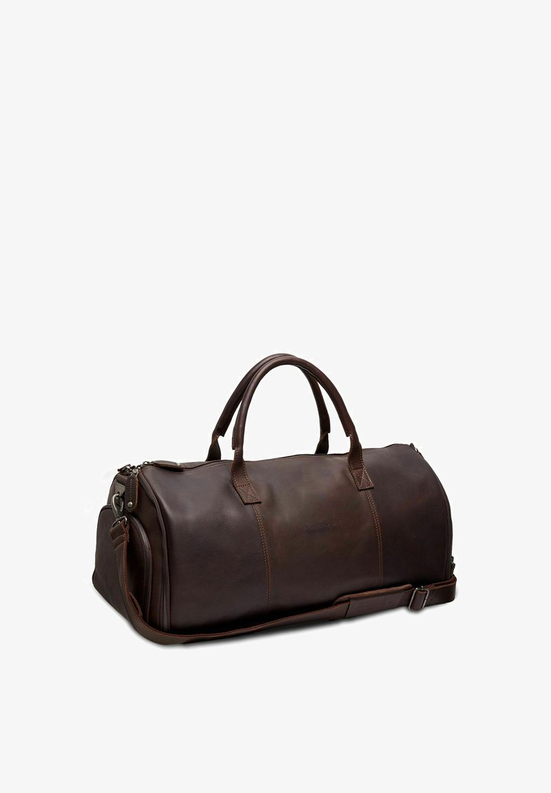 Bolsa de viaje de cuero marrón con asas dobles, correa de hombro ajustable, cierre con cremallera y un sutil detalle de costura para mayor durabilidad.