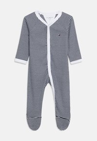 Βρεφικό φορμάκι με μακρυμάνικα, καλυμμένα πόδια, κουμπιά ασφαλείας μπροστά σε ριγέ σχέδιο σε ναυτικό μπλε και άσπρο, με μικρό λογότυπο Tommy Hilfiger στο στήθος.