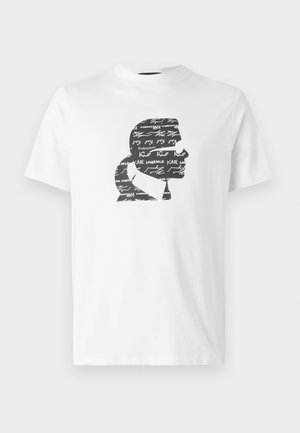 Valge puuvillane t-särk, millel on must siluett profil, millel on overlappivad tekstid ja allkirjad, luues mustri efekti.