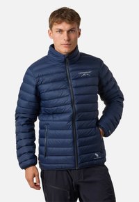 Giacca a vento blu navy con colletto alto, pannelli cuciti e due tasche laterali con zip. Presenta il logo sul lato sinistro del petto. Texture liscia.