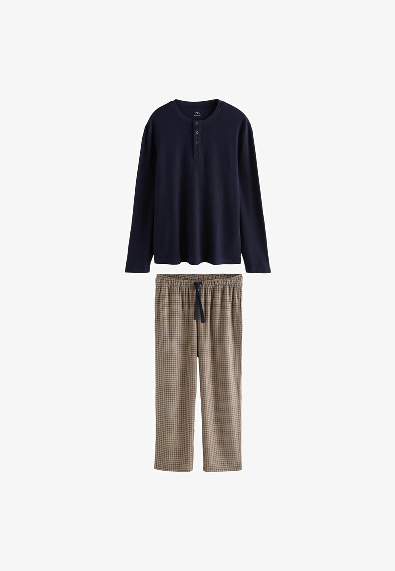T-shirt henley à manches longues bleu marine avec trois boutons, associé à un pantalon de pyjama beige et marron à carreaux avec une taille à cordon.