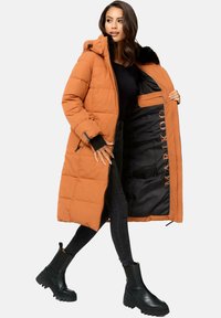 Abrigo largo acolchado naranja con capucha, forro interior negro y bolsillos con cremallera. Presenta un diseño acolchado y acentos negros.