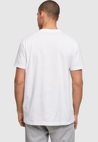 Witte katoenen t-shirt met korte mouwen en een ronde hals, met een soepele textuur en een standaard pasvorm, van achteren getoond.