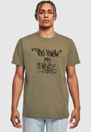 Olive green cotton t-shirt with a round neck, featuring black graffiti-style text: "YOU KNOW!" and "my stegz" across the front.