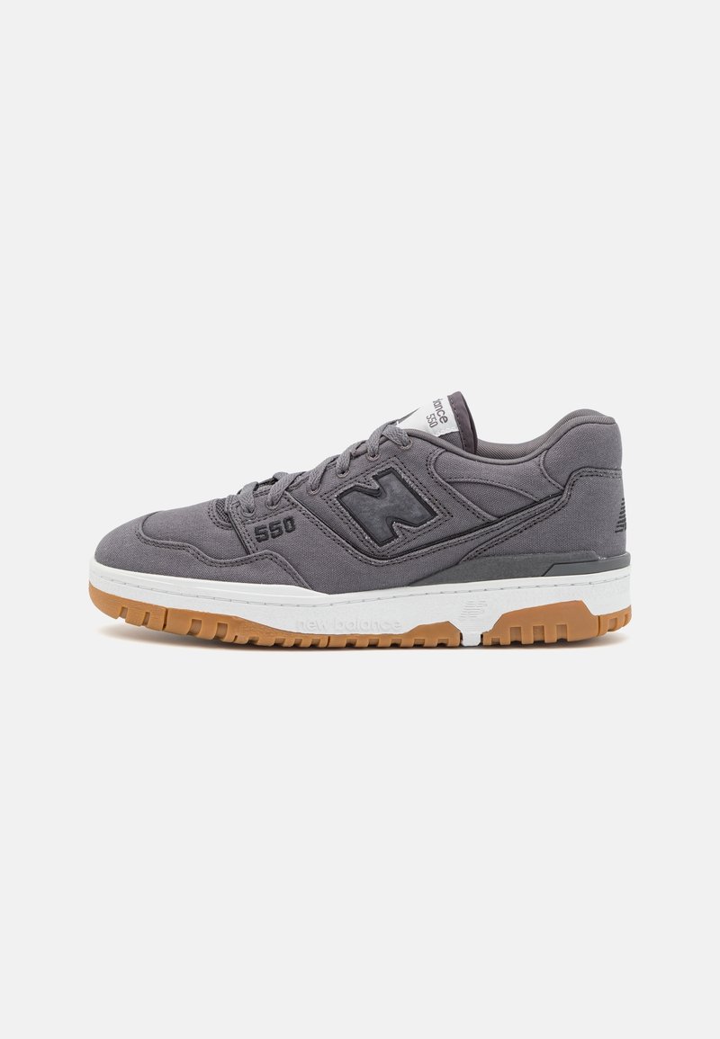 Baskets New Balance 550 grises avec logo noir, semelle intermédiaire blanche et semelle extérieure en caoutchouc naturel, présentées de profil sur fond blanc.