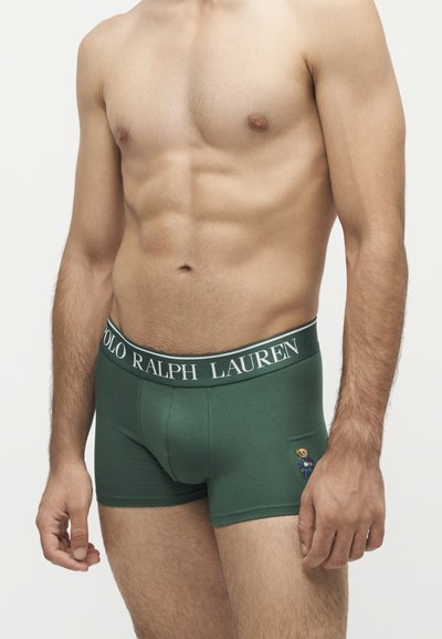 Мъжки торс във форма, носещ зелени боксерки Polo Ralph Lauren с лого на колана и малък емблем на мечка на лявото бедро.
