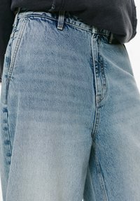 Hellblaue Denim-Jeans mit hoher Taille, geradem Schnitt und dezenten Used-Effekten. Verfügt über gestickte Nähte und einen Reißverschluss vorne.