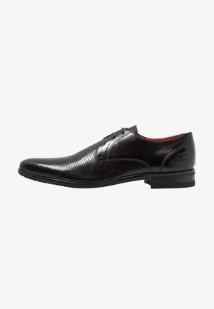 Czarny męski elegancki but ze skóry z perforowanym wzorem, sznurowaniem i niskim obcasem, widoczny z boku na białym tle.