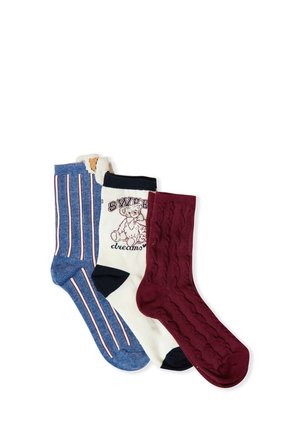 Drei Paar Socken: blau mit vertikalen Streifen, cremefarben mit Bären-Graphic und Text sowie kastanienbraun mit Kabelstricktextur.