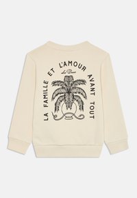 Sweatshirt color crema con grafica di palma e testo francese sul retro; presenta polsini e orlo a coste per un look aderente.