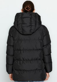Czarna kurtka puchowa z kapturem, z pikowanymi sekcjami, gładką fakturą i luźnym krojem. Brak widocznych elementów metalowych lub ozdób.