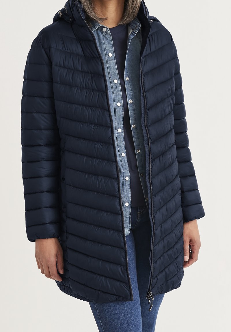 Granatowa kurtka puchowa z zamkiem z przodu, kapturem i poziomymi przeszyciami. Wykonana z gładkiego, lekkiego materiału. Luźny krój.