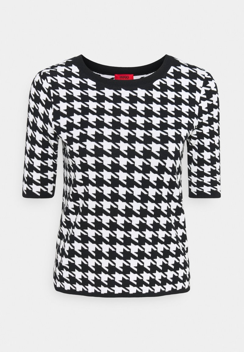 Haut en maille noir et blanc à manches courtes avec un motif pied-de-poule et un col rond bordé de noir.