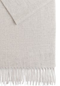 Hellgrauer Schal mit einer weichen, strukturierten Webart. Verfügt über fransige Kanten für zusätzliche Details. Einfaches und vielseitiges Design, geeignet für verschiedene Anlässe.