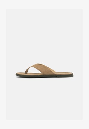 Pruun sametise pealispinnaga tangisandaal polsterdatud tallaga ja lameda musta tallaga, näidatud külgvaates valgel taustal.