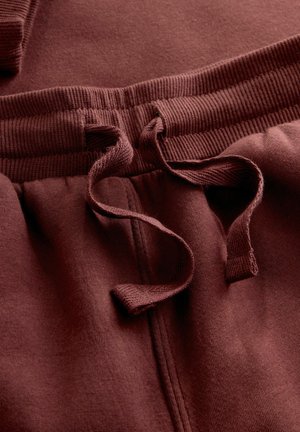 Bordeaux sweatpants met geribbeld taillekoord en verstelbare koord. Zacht, gladde stof met een subtiele textuur en geen zichtbare zakken.