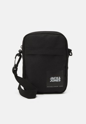 Sort crossover taske lavet af slidstærkt stof. Funktioner inkluderer en frontlomme, justerbar rem og et logo patch med "JACK & JONES."