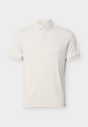 Lys beige kortermet polo med tre knapper, liten logo på kragen og brodert merkenavn på venstre erme.