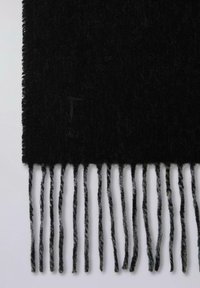 Sort uldhalstørklæde med en tekstureret finish og lange frynser i forskellige nuancer af grå. Diskret logodetalje til stede.