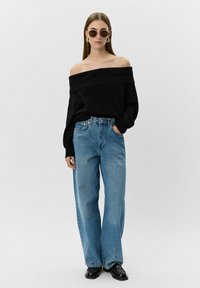 Melna off-shoulder džemperis, gaiši zili plati bikses, apaļas saulesbrilles, zelta auskari un melnas kurpes. Gluda auduma ar brīvu piegriezumu.