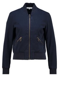 Námořnická bombardérka vyrobená z hladké látky, se zapínáním na zip vpředu, dvěma bočními zipovými kapsami, vroubkovanými manžetami a dolním lemem. Jednoduchý a moderní design.