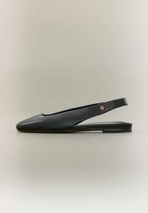 Mustast nahast slingback madala kontsaga king, terava kärje ja kuldse logoga rõhutusega rihmal, esitatuna neutraalsel taustal.