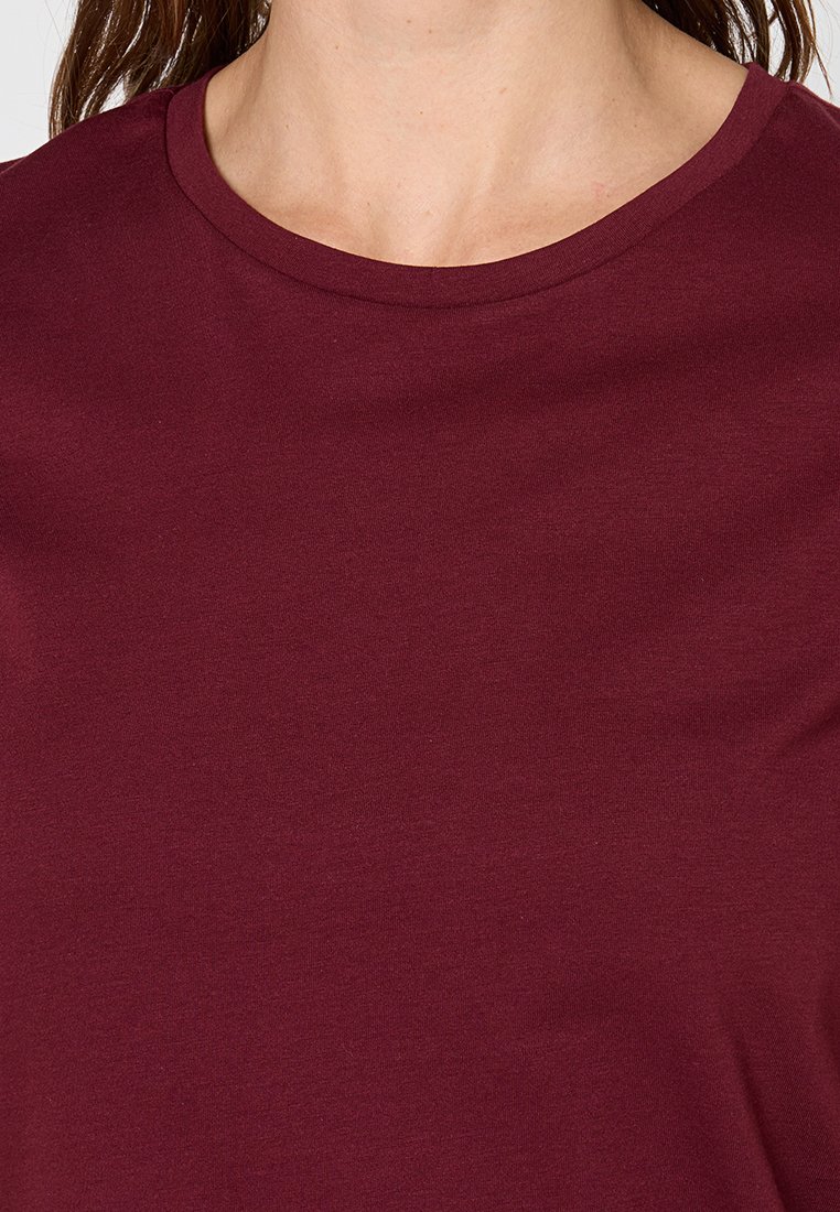 Burgunderfarbenes Rundhals-T-Shirt aus weichem Baumwollmix; glatte Textur mit klassischem, lässigem Schnitt und ohne sichtbare Muster oder Akzente.