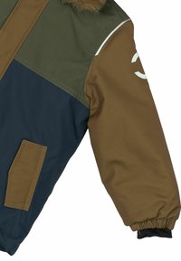 Spalvotai blokuota parka, kuri turi alyvmedžio žalia, jūros mėlynumo ir rudos spalvos paneles, su pūkine kapisonu, elastinėmis rankogaliais ir balta logotipo detale ant rankovės.