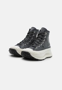 Hoge sneakers in donkergrijs textiel met witte rubberen zolen. Voorzien van een gestructureerde zwarte loopzool en zilveren oogjes. Versterkte neuskap en logodetail.