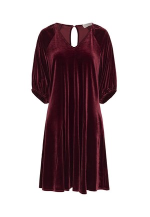 Burgundi bársonydressz V-kivágással, rövid puff ujjakkal és kulcslyuk kialakítással a hátsó részen. Díszes formáját függőleges varrások emelik ki.