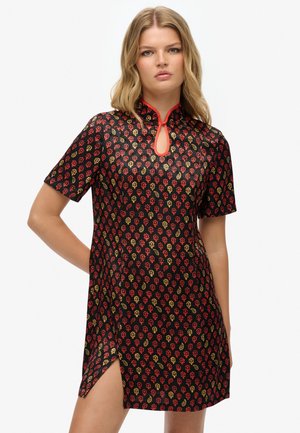 Robe à manches courtes en tissu noir avec un motif floral rouge et doré, décolleté en forme de clé et fentes latérales pour plus de détail.