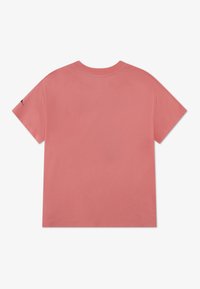 Βαμβακερό T-shirt σε σταθερό κοραλί ροζ χρώμα με άνετη εφαρμογή, κοντά μανίκια και μικρή λεπτομέρεια λογότυπου στο μανίκι. Ομαλή υφή.