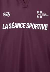 Maroon athletic jersey with a V-neck, featuring white text "LA SÉANCE SPORTIVE" and logos on the upper left and right. Smooth texture.