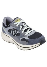 Chaussure de sport grise en matériaux mesh et daim, avec des lacets blancs, une semelle rembourrée et une étiquette d'accent jaune sur la languette.