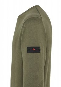 Olivgrünes Langarmhemd aus strukturiertem Stoff. Verfügt über einen schwarzen Fleck am Ärmel mit zwei Knöpfen und drei roten Punkten.