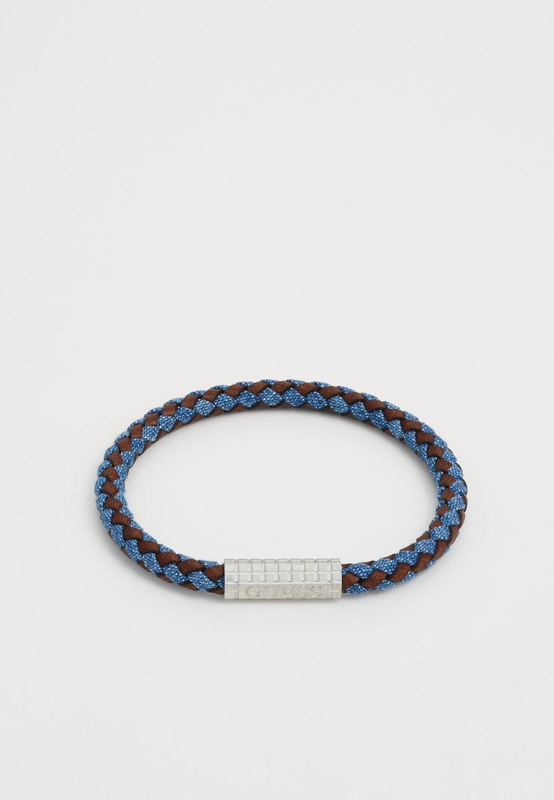 Vævet armbånd med blå og brune fibre, med en sølvmetal lås, der viser brandnavnet, GUESS. Cirkulær form med tekstureret overflade.
