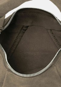 Interno di borsa in suede nero con chiusura a zip. Caratterizza una texture liscia e un design pulito e spazioso. Include fodera in tessuto e tasche interne.