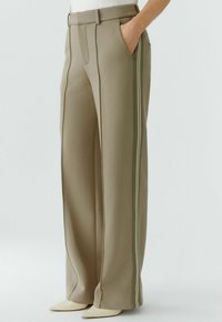 Beige Hosen mit weitem Bein aus glattem Stoff, mit auffälligen Seitenstreifen und Seitentaschen, versehen mit einem strukturierten Bund.