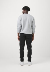Champion ICONS HEM PANTS - Treniņtērpa apakšdaļas - black