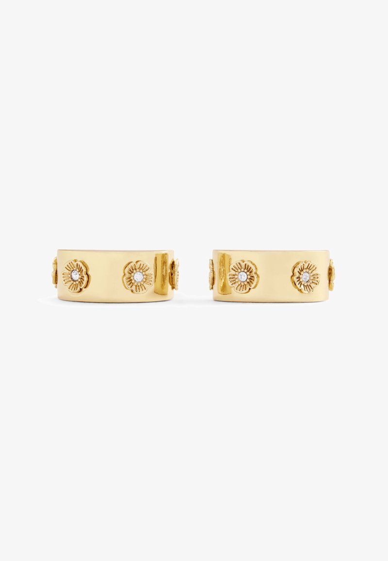 Gold-toned metal earrings with a smooth finish, featuring flower-shaped accents and small clear gems integrated into the design.