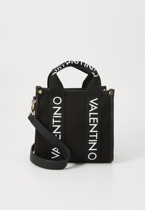 Sort stof Valentino håndtaske med to korte håndtag og hvid logo tekst på stropper, plus en aftagelig skulderrem og gyldne hardware-detaljer.
