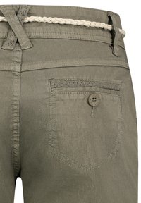 Olivegrüne Hosen mit glatter Textur, ausgestattet mit einer Gesäßtasche mit einem Knopf und einem geflochtenen, hellen Gürtel in der Taille.