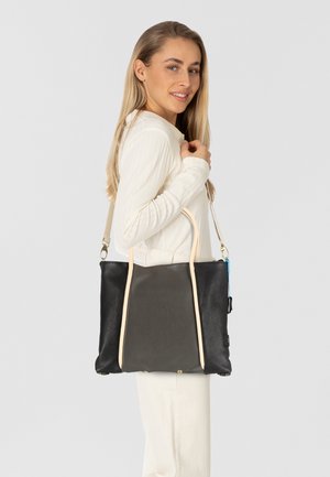 Schwarze Ledertasche mit hellbeigen Griffen und Metallakzenten. Rechteckige Form mit strukturierten Oberflächen und seitlichen Taschen.