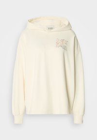 Κρεμ καπέλο φτιαγμένο από μαλακό ύφασμα. Διαθέτει κουκούλα με κορδόνια και γραφιστικό σχέδιο σε παστέλ χρώματα στο στήθος, με ριμπ μανσέτες.