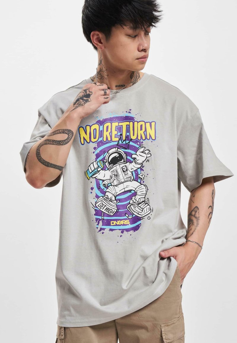Lys grå grafisk t-shirt med et astronautdesign i lilla, gul og sort. Kortærmet og afslappet pasform med synlige tatoveringer.
