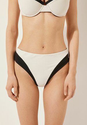 Bikini-set met textuur in witte stof en zwarte accenten. De top heeft een gevormd ontwerp; de onderkant heeft een hoog taille-stijl met hoekige lijnen.