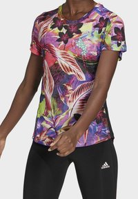 Mikina s krátkým rukávem a kulatým výstřihem s multicolor grafickými květinovými vzory, spárovaná s černými legínami s logem.